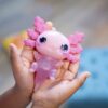 De Let's Glo Axolotl in de handen van een kind