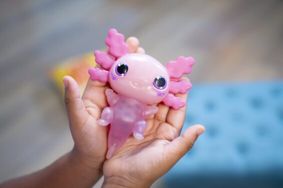 De Let's Glo Axolotl in de handen van een kind