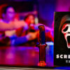 De doos van Scream the Game met mensen op de achtergrond die het spel spelen